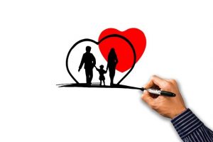 Hand sketching a family inside a heart
